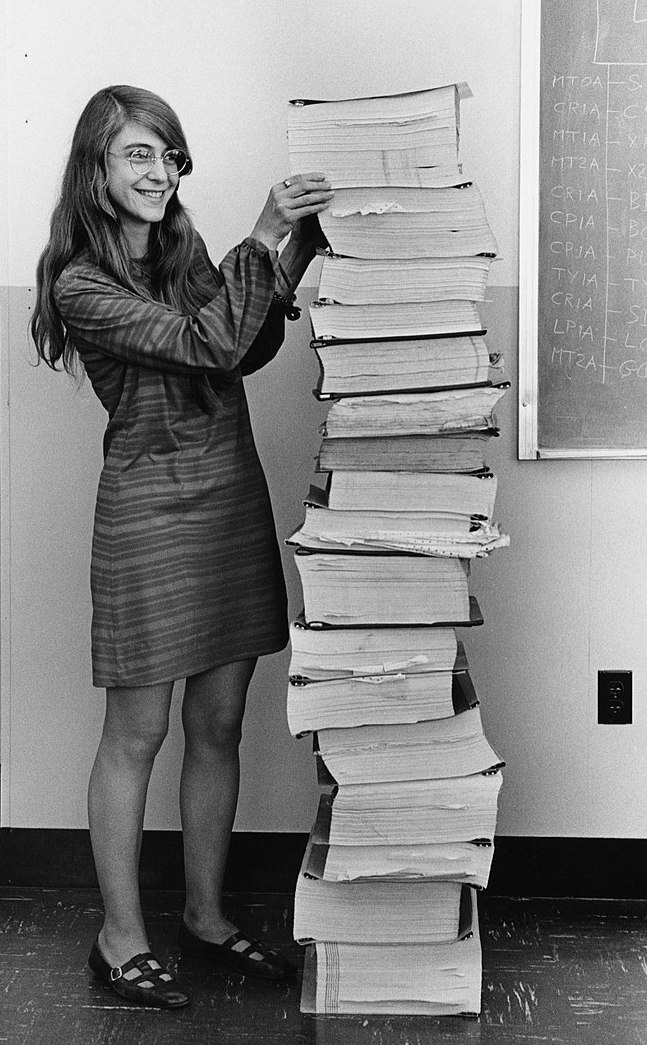 Software engineering pioneer Margaret Hamilton standing beside a
	 listing of the software, developed by the team she led, for the Apollo
	 space project